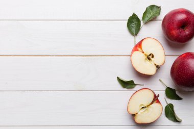 Tahta masada yeşil yapraklı taze kırmızı elmalar. Ahşap arka planda. Metin için üst görünüm boş alanı.