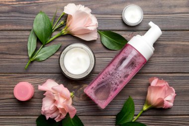 Kozmetik ürünleri ve ahşap arka planda güzel güller olan kompozisyon. Düz yatıyordu.