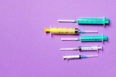 Mor arkaplanda farklı şırıngaların üst görünümü. Kopya alanı ile tıbbi enjeksiyon kavramı.