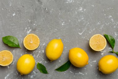 Renkli arka planda yeşil yapraklı taze limonlar, üst görünüm, metin için boşluk.