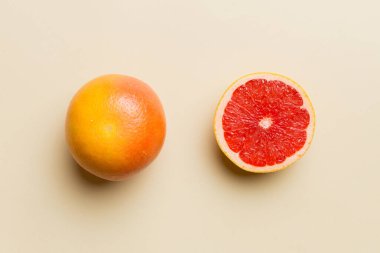Renkli arka planda sulu greyfurt dilimli taze meyve greyfurdu. Üst Manzara. Uzayı kopyala yaratıcı yaz konsepti. Minimum düzlükte turunçgillerin yarısı kopyalama alanı ile yatar.