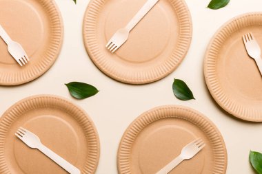 Açık beyaz masa arkaplanındaki boş, tek kullanımlık çevre dostu tabaklar, bardaklar, çatal bıçaklar. Üst Manzara. Biyo-çözünebilir el yapımı yemekler. Geri dönüşüm konsepti. Yakın plan..