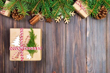 Noel köknar ağacı ve hediye kutusu ahşap masa üzerinde arka plan. Tasarımınız için kopya alanı ile üstten görünüm.