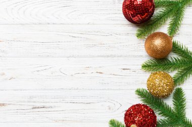 Noel kompozisyonu köknar ağacı, toplar ve ahşap arka planda farklı dekorasyonlardan oluşur. Tasarımınız için boş alanı olan Yeni Yıl Advent konseptinin üst görünümü.