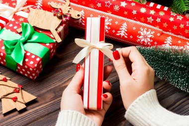 Kadın eli görüntüsü, yeni yılı şenlikli ahşap arka planda kutluyor. Firavun ağacı ve tatil süslemeleri. Noel zamanı konsepti.