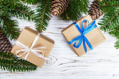 Noel hediye kutusu beyaz ahşap masa arka plan, Ladin şube, çam kozalakları, çerçeve, üstten görünüm, metin için yer.
