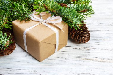 Noel hediye kutusu beyaz ahşap masa arka plan, Ladin şube, çam kozalakları, çerçeve, üstten görünüm, metin için yer.