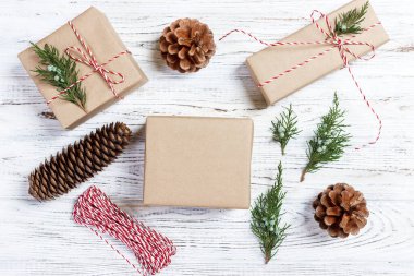 El hazırlanmış hediyeler, Noel arka plan üzerinde rustik ahşap masa sunar. Noel ve yeni yıl DIY ambalaj. Tatil dekorasyon konsepti. Genel gider, düz yatıyordu, en iyi görünümü.