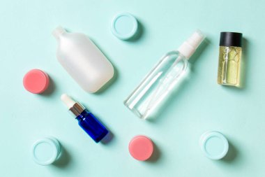 Kozmetik SPA marka modeli, fotokopi alanı olan üst görünüm. Renkli arka planda duran krema tüpleri ve kavanozları..