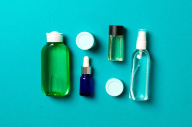 Kozmetik SPA marka modeli, fotokopi alanı olan üst görünüm. Renkli arka planda duran krema tüpleri ve kavanozları..