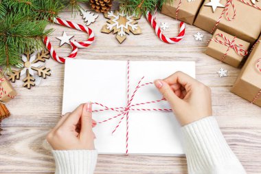 Birçok zarf ip ile bağladılar. Yakın çekim yukarıdan famale el ile zarf. Çam koniler ve Noel dekorasyonu eski ahşap tablo, Resepsiyon.