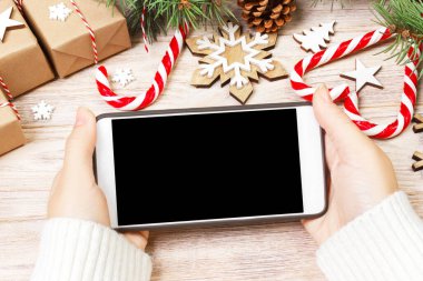 Noel online alışveriş. Kadın alıcı kopya alanı ile akıllı telefon ekranında sipariş yapar. Kadın hediyeleri Noel arifesi için satın alır, oturur, evde bir şekilde dekore edilmiş yakınındaki. Kış tatil satış.