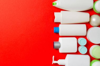 Farklı kozmetik şişeleri ve renkli arka planda kozmetik ürünleri için konteynır. Kopya alanı olan düz konum.