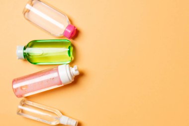 Kozmetik SPA marka modeli, fotokopi alanı olan üst görünüm. Renkli arka planda duran krema tüpleri ve kavanozları..