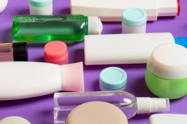 Farklı kozmetik şişeleri ve renkli arka planda kozmetik ürünleri için konteynır. Kopya alanı olan düz konum.