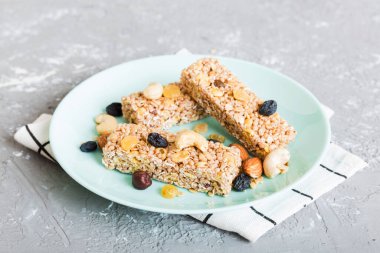 Arka planda çeşitli granola barlar var. Mısır gevreği gofretleri. Yulaf, fındık ve böğürtlenli kahvaltı barları, yakın çekim. Süper yiyecek konsepti.