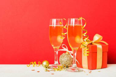 Champagne glasses and christmas decor on colored holiday background. Flat lay New Year decorations.
