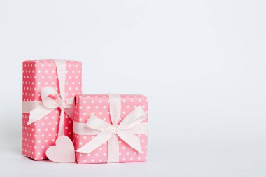gift box with red bow and red heart on colored background. Perspective view. Flat lay.