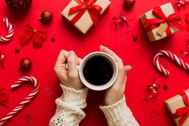 Elinde bir fincan kahve tutan kadın. Kadın elleri bardağı sıcak kahveyle tutuyor. Kış ve Noel zamanı kavramı.