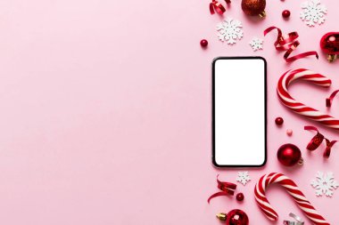 Digital phone mock up with rustic Christmas decorations for app presentation top view with empty space for you design. Christmas online shopping concept. Tablet with copy space on colored background.