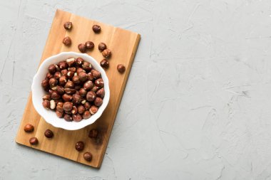 Wooden bowl full of hazelnuts on table background. Healthy eating concept. Super foods.