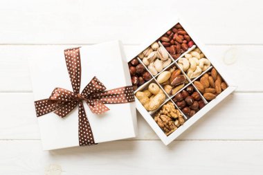 Various varieties of nuts lying in paper box on table background. Top view. Healthy food. Close up, copy space, top view, flat lay. Walnut, pistachios, almonds, hazelnuts and cashews.