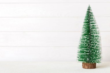 One small Christmas tree on colored background. new year decoration with copy space.