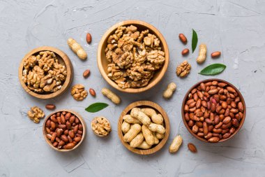 Ceviz çekirdeği yarım, ahşap bir kasede. Yakın plan, yukarıdan, renkli arkaplanda. Sağlıklı beslenme kavramı. Kopyalama alanı olan süper gıdalar.