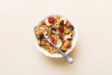 Sağlıklı bir kahvaltı hazırlıyorum. Bir kasede çeşitli kurutulmuş meyve ve fındıklı granola. Sağlıklı tatlı kavramı. Düz konum, kopyalama alanı olan üst görünüm.