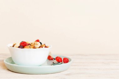 Sağlıklı bir kahvaltı hazırlıyorum. Bir kasede çeşitli kurutulmuş meyve ve fındıklı granola. Sağlıklı tatlı kavramı. Düz konum, kopyalama alanı olan üst görünüm.