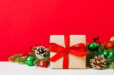 New Year Christmas mood, gift box, branches of a christmas tree, New Year decorations on a colored background.