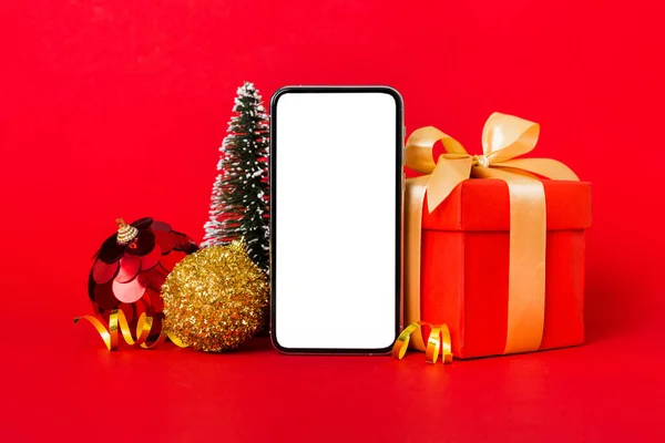 Digital phone mock up with rustic Christmas decorations for app presentation with empty space for you design. Christmas online shopping concept. Tablet with copy space on colored background.