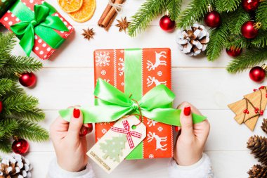 Kadın eli görüntüsü, yeni yılı şenlikli ahşap arka planda kutluyor. Firavun ağacı ve tatil süslemeleri. Noel zamanı konsepti.