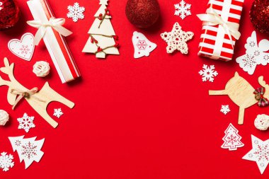 Kırmızı arka plandaki Noel süslemelerinin en üst görüntüsü. Fotokopi alanı olan yeni yıl tatili kavramı.