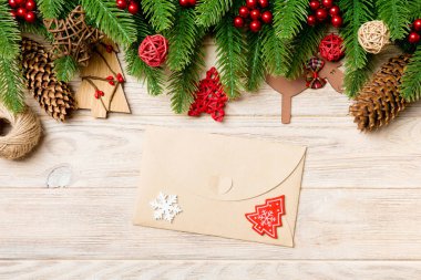 Zarfın en üst görüntüsü, Noel oyuncakları, dekorasyonlar ve ahşap arka planda köknar dalları. Yeni yıl tatili konsepti.