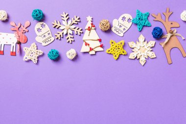 Mor arka planda şenlikli dekorasyon ve oyuncaklar. Fotokopi alanı ile Mutlu Noeller.