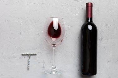 Tirbuşonlu düz kompozisyon, bir şişe şarap ve renkli masada zarif bir cam. Düz konum, üst görünüm kopyalama alanı.