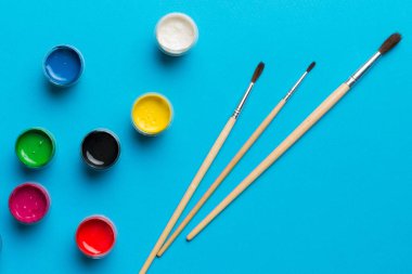 Boya ve fırçalı palet, yakın çekim. Boşluğu olan üst görünüm. Yaratıcılık için işyeri. ev öğretmenliği kavramı çizimi.