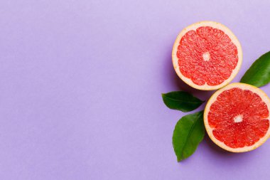 Renkli arka planda sulu greyfurt dilimli taze meyve greyfurdu. Üst Manzara. Uzayı kopyala yaratıcı yaz konsepti. Minimum düzlükte turunçgillerin yarısı kopyalama alanı ile yatar.