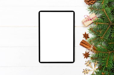 Dijital tablet kadar app tanıtımı için rustik Noel ahşap arka plan süslemeleri ile alay. kopya alanı ile üstten görünüm.