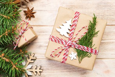 Noel köknar ağacı ve hediye kutusu ahşap masa üzerinde arka plan. Tasarımınız için kopya alanı ile üstten görünüm.