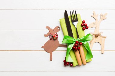 Noel süslemeleri ve ahşap arka planda ren geyiği olan peçetedeki yeni yıl aletlerinin en üst görüntüsü. Fotokopi alanı ile Noel yemeği konsepti.