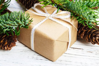 Noel hediye kutusu beyaz ahşap masa arka plan, Ladin şube, çam kozalakları, çerçeve, üstten görünüm, metin için yer.