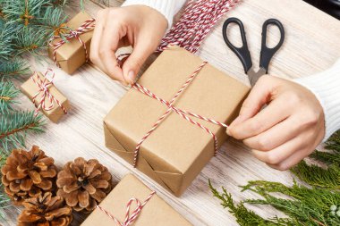 Noel hazırlık sunar. Siyah ve beyaz çizgili kağıt, çam kozalakları ve Noel oyuncak ve ambalaj malzemeleri bir beyaz tahta eski arka plan üzerinde dolu bir sandık sarılmış hediye kutusu.