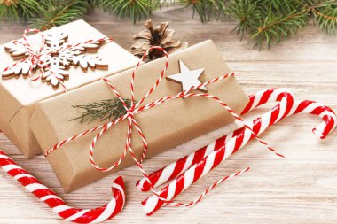Köknar ağacı dalı Noel hediye kutusu ve şeker ile kopya alanı ile ahşap arka plan üzerinde köpekler.