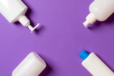 Renkli arkaplanda izole edilmiş Beyaz Kozmetik konteynırları seti, fotokopi alanı ile üst görünüm. Senin için bir grup plastik kaplar ve boş bir yer tasarladın..