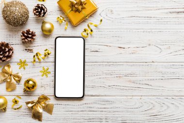 Digital phone mock up with rustic Christmas decorations for app presentation top view with empty space for you design. Christmas online shopping concept. Tablet with copy space on colored background.