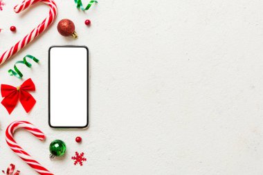 Digital phone mock up with rustic Christmas decorations for app presentation top view with empty space for you design. Christmas online shopping concept. Tablet with copy space on colored background.