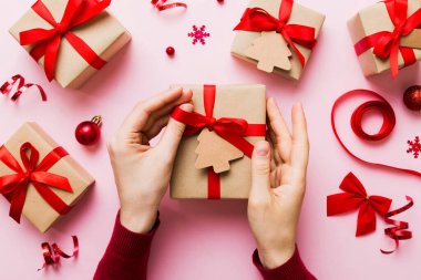 Kadın eli hediye kutusunu tutuyor, sürprizi hazırlıyor, üst manzara, Noel ve yeni yıl konsepti.