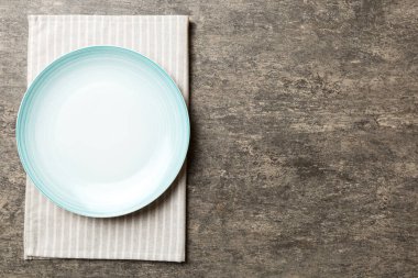 Renkli arkaplanda üst görünüm yiyecek için mavi tabak üzerinde boş. Tasarımınız için boşluk olan peçeteye boş tabak.